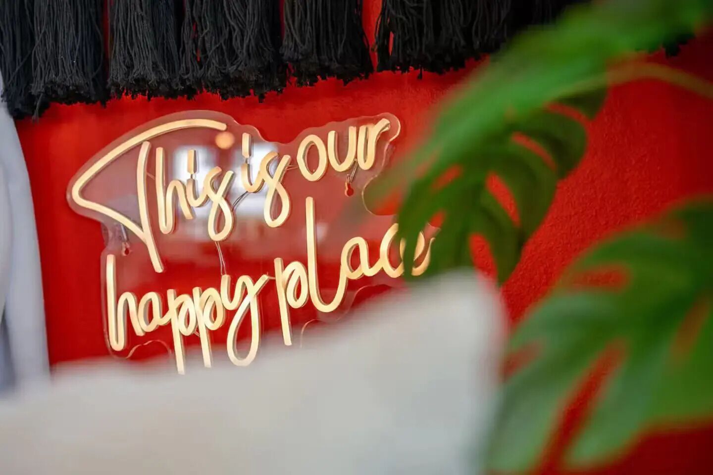 Un letrero de neón con el texto 'Este es nuestro lugar feliz'.