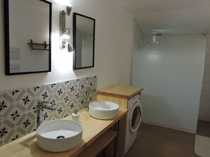 A bathroom with a sink, mirror, and washing machine. - "Gîte La Cerise sur le Gâteau" Spacious country house with private garden. (Sainte-Marie)