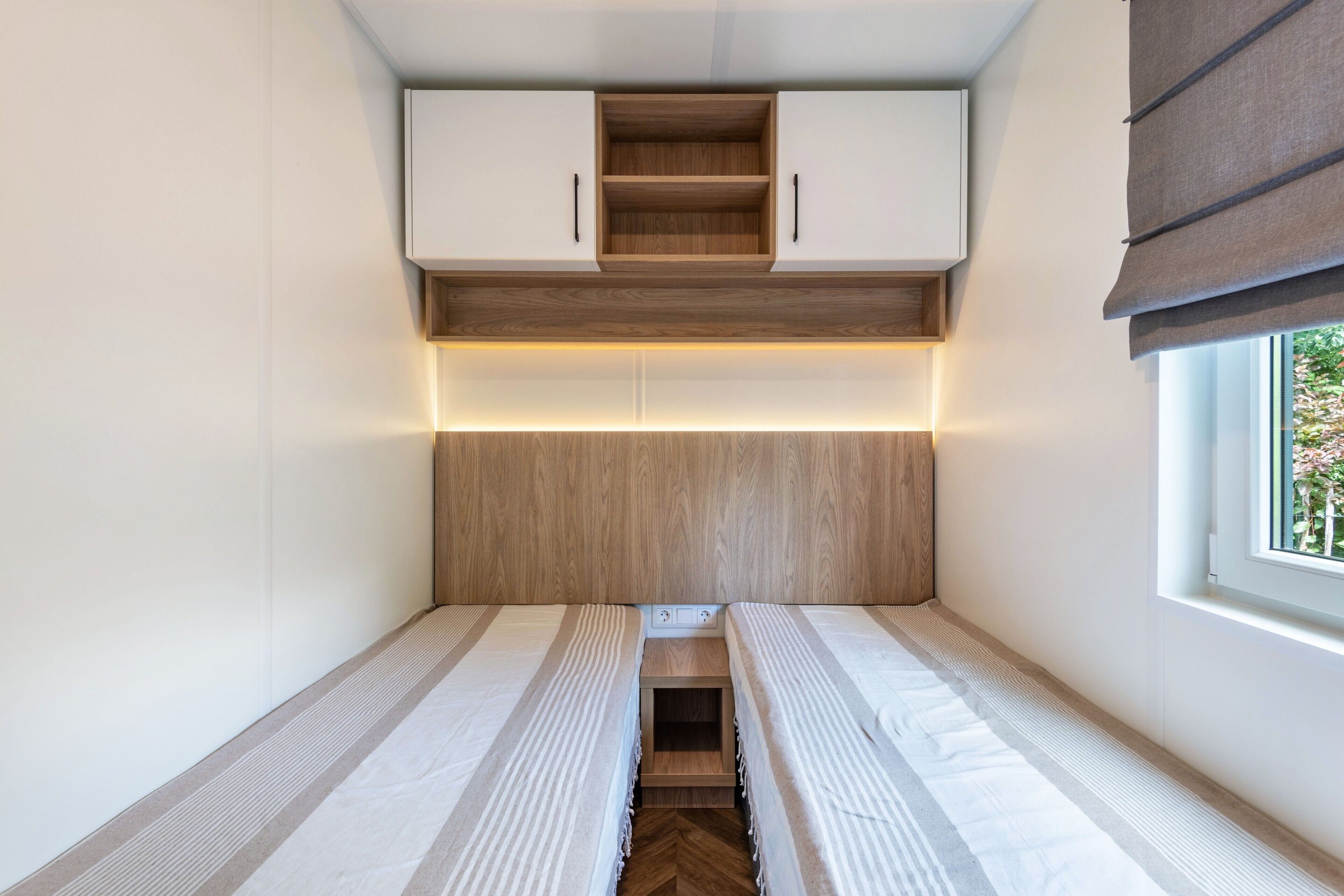 A compact room with a bed, a small table, and a window.