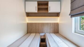 A compact room with a bed, a small table, and a window.