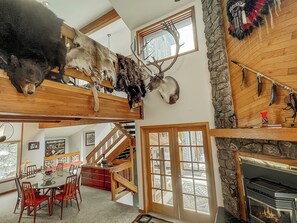 Ein großzügiger Innenraum mit Essbereich, Kamin und Treppe.