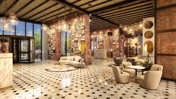 A spacious lobby with a checkered floor, a brick wall adorned with pictures, and a mix of seating areas including sofas and armchairs. - Bomonti Suites (Istanbul)