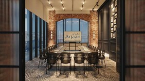 A conference room with a long table and chairs, a large window, and a sign reading 'Arjaan Hotel Apartments.' - Bomonti Suites (Istanbul)