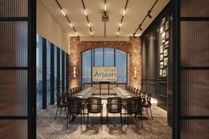 A conference room with a long table and chairs, a large window, and a sign reading 'Arjaan Hotel Apartments.' - Bomonti Suites (Istanbul)