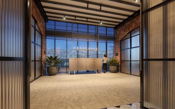 Eine großzügige Lobby mit großen Fenstern, einer hohen Decke und Blick auf die Stadt.