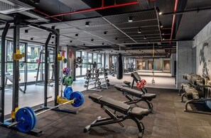 A gym with weightlifting equipment, benches, and cardio machines. - Bomonti Suites (Istanbul)