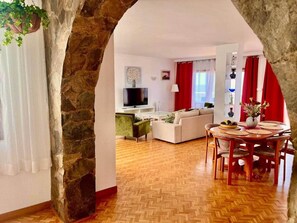 A living room with a herringbone floor, a dining area with a wooden table and chairs, and a kitchen in the background. - Seaview Muelle en pleno centro, Puerto de la Cruz (Puerto de la Cruz)