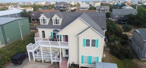 A two-story house with a balcony, a garage, and a driveway.