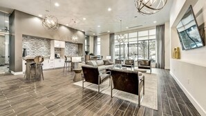 A spacious living area with a modern kitchen, large windows, and contemporary furnishings. - Landing Furnished Apartments near UT Arlington (Arlington)