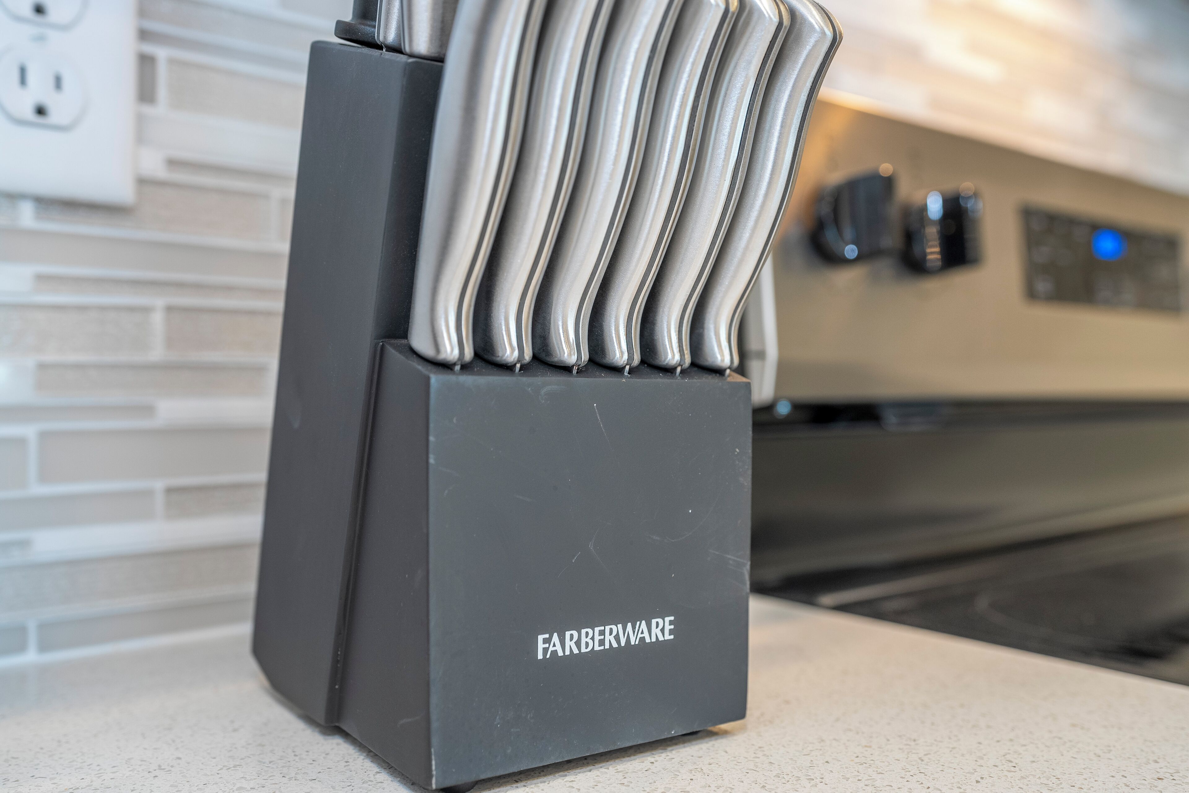 A kitchen counter with a Farberware knife block.