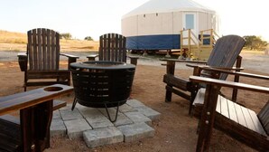 A yurt with a covered entrance, surrounded by outdoor seating and a fire pit. - Glamping getaway Yurt with A/C in Johnson city (Johnson City)