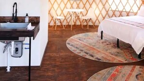 A yurt interior with a round bed, a small table, and a hanging light fixture. - Glamping getaway Yurt with A/C in Johnson city (Johnson City)