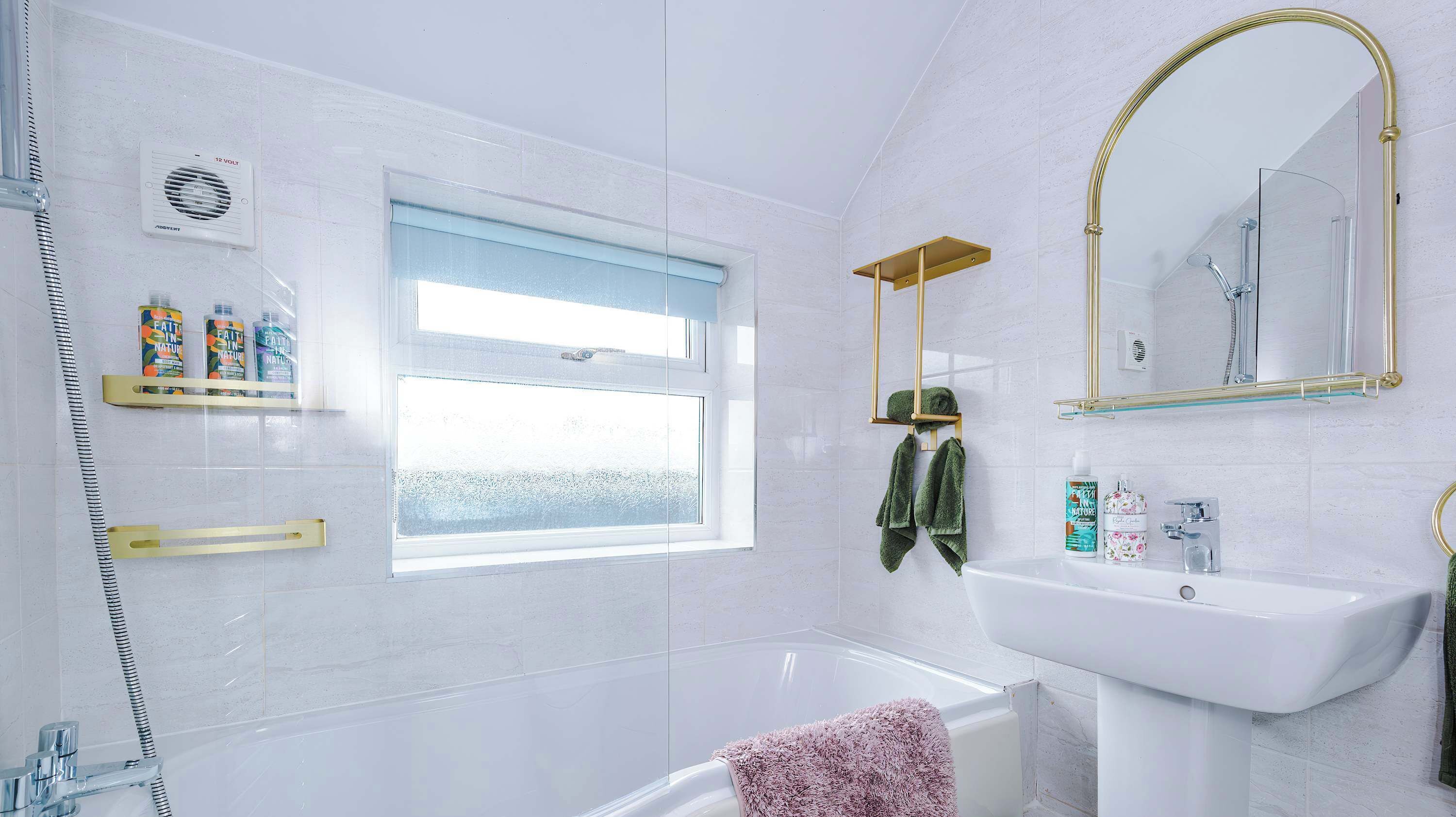 Une salle de bain moderne avec une baignoire, un lavabo, une fenêtre et une douche.