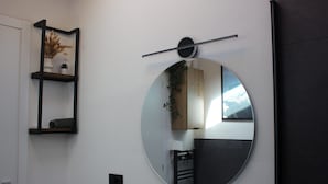 A room with a round mirror, a shelf with decorative items, and a door. - Bright Design Loft - Milan Certosa District (Milano)