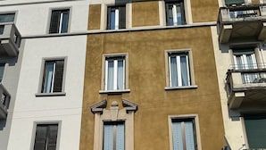 A multi-story building with a large central entrance, multiple windows, and balconies. - Bright Design Loft - Milan Certosa District (Milano)