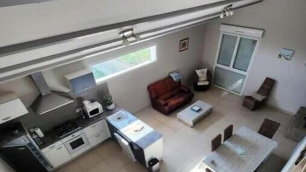 Een ruimtelijke leefruimte met een kitchenette, een eethoek en een zithoek.