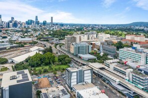 A cityscape with modern buildings, a highway, and green spaces. - Bright Bowen Hills 2BR Escape Near CBD (Brisbane)