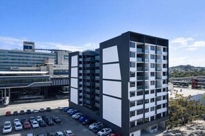 A multi-story building with a parking lot in front. - Bright Bowen Hills 2BR Escape Near CBD (Brisbane)