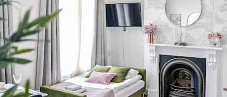 Tabla de planchar con plancha, internet y ropa de cama