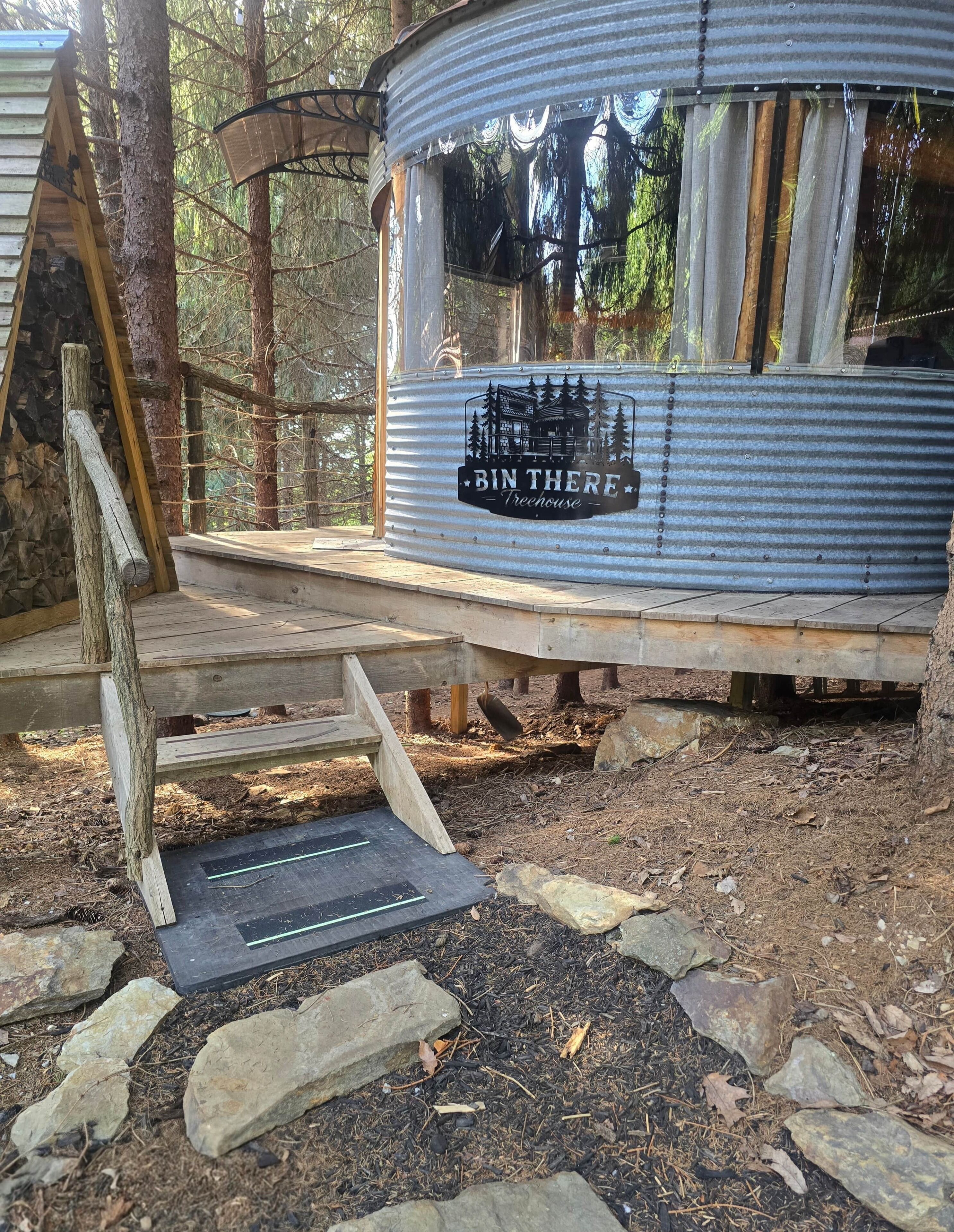 A rustic cabin with a metal exterior and a wooden deck.