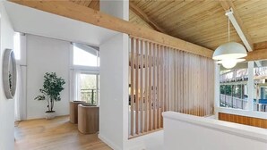 Ein modernes Interieur mit Holzbalken, einem Topfpflanzen und Blick ins Freie.