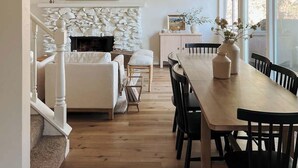 Et moderne interiør med spiseplads, pejs og et fjernsyn ophængt på væggen.