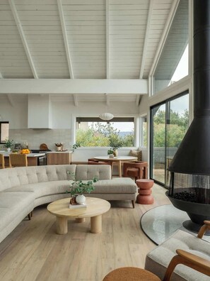 A modern living room with a large sectional sofa, a round coffee table, and a fireplace. - Seven Peaks (w/ lake views, lake access!) (Lake Arrowhead)