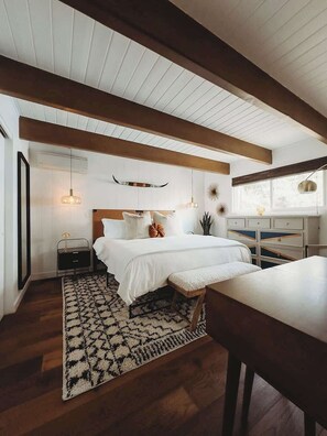 A bedroom with a bed, bedside tables, a rug, and a window. - Harlow House, w/ hot tub, lake view & lake access! (Lake Arrowhead)