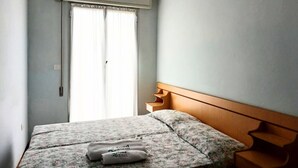 A bedroom with a bed, a window with curtains, and a wall-mounted air conditioning unit. - RG019 - Bellaria, bright three-room apartment 100 meters from the sea (Bellaria-Igea Marina)