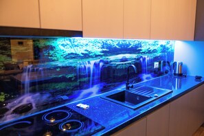 A kitchen with a built-in waterfall feature, a sink, and a stove.