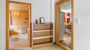 Un intérieur en bois comprenant un meuble en bois, une petite table de chevet et une étagère.
