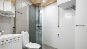 Ein modernes Badezimmer mit Toilette, Waschbecken und Dusche.