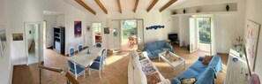 Ein geräumiger Wohnbereich mit Esstisch, Sofas und Fernseher.