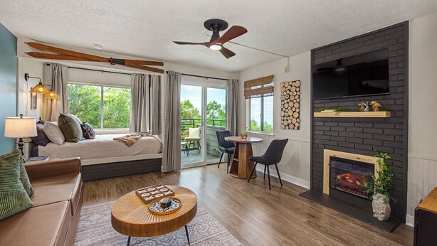 A modern living room with a fireplace, a sofa, a coffee table, and a TV mounted on the wall.