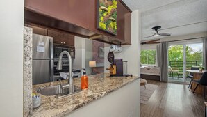 A modern kitchen with granite countertops, stainless steel appliances, and a dining area with a view.