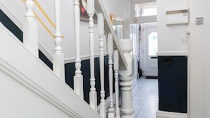 Eine Treppe mit weißen Balustraden, einer dunklen Wand und einem gefliesten Boden.