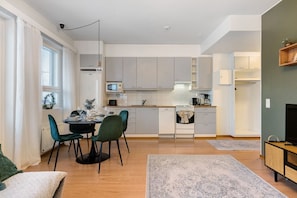 Een moderne keuken met een eetgedeelte, een televisie en een zithoekje.
