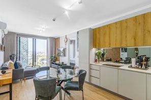 Eine moderne Wohnung mit Essbereich, Küche und großen Fenstern mit Blick auf die Stadt.