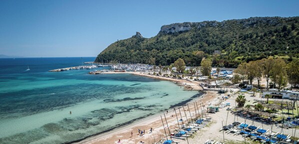 A coastal area with a beach, boats, and a mountainous backdrop. - Alba e Tramonto - One Bedroom Apartment, Sleeps 4 (Cagliari)