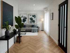 Ein modernes Wohnzimmer mit einer Couch, einem Couchtisch und einer Topfpflanze.