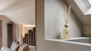 A modern interior with a sofa, a decorative vase, and a sloped ceiling. - Wyke View Ridgestone (Windermere)