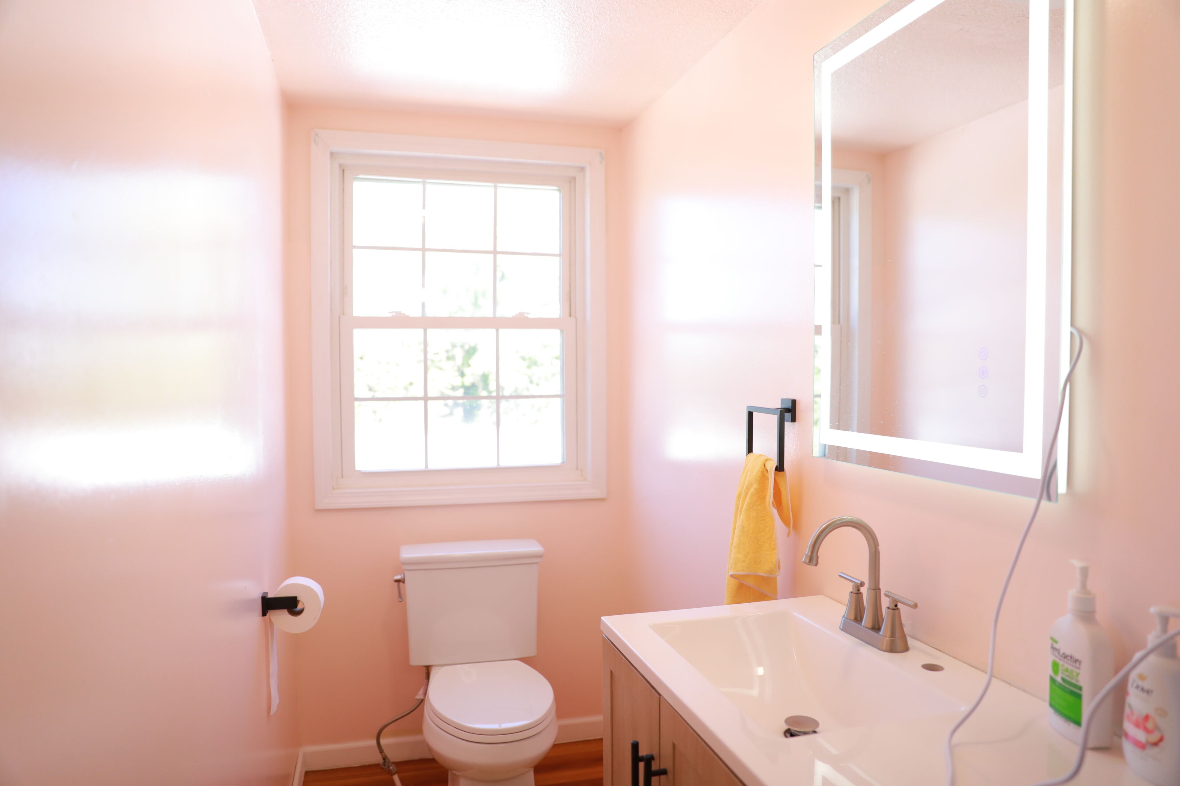 Une salle de bain avec des toilettes, un lavabo et une fenêtre.