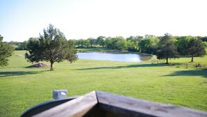 A grassy field with a pond, trees, and a wooden fence. - Private Country Suite Near Truman Lake & Fishing (Clinton)