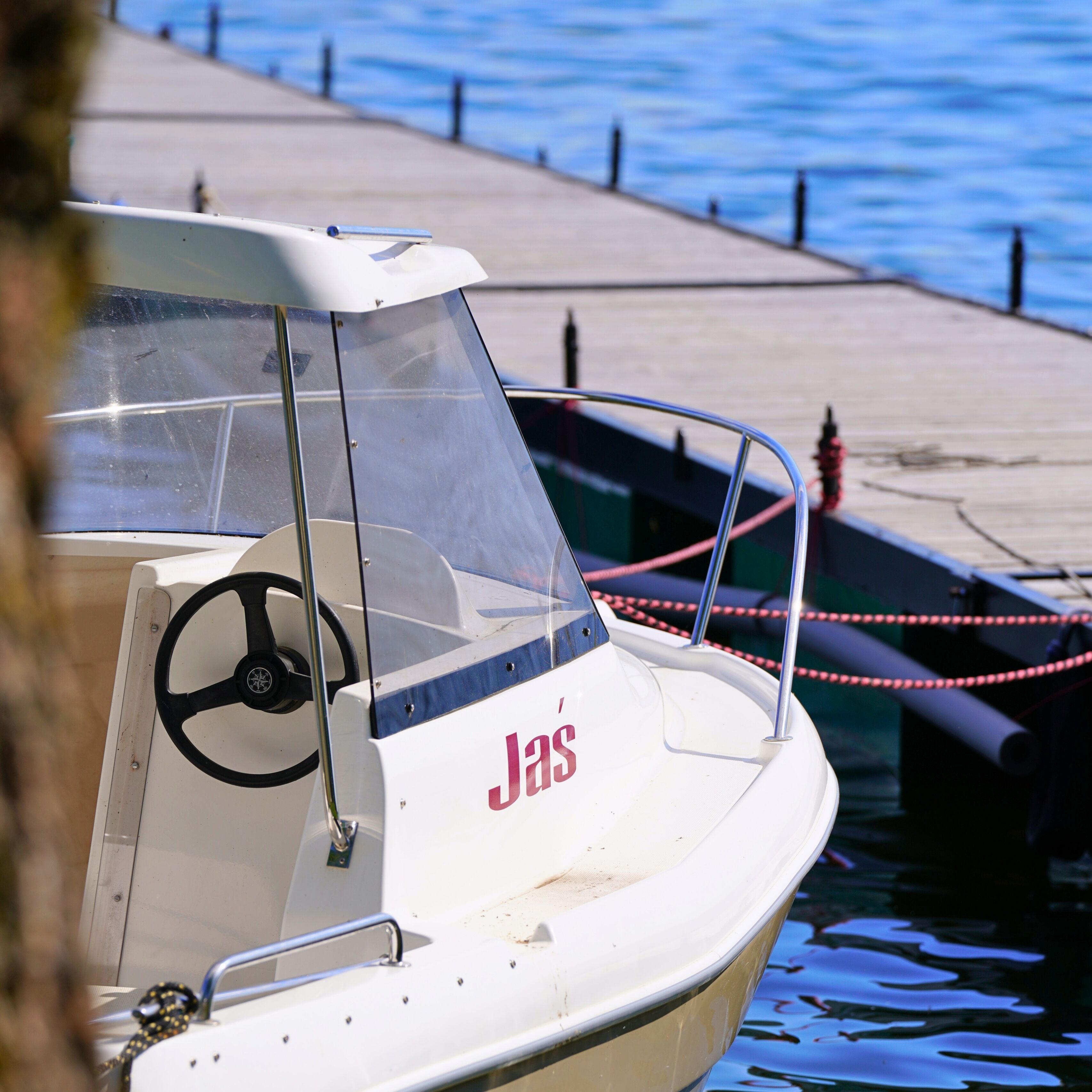 A boat docked at a pier with a clear view of the water.