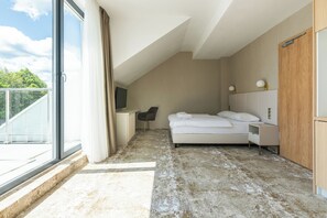 A modern bedroom with a large window, a bed, a desk, and a chair.