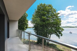A balcony with a view of a lake and trees.