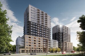 En moderne højhusbygning med flere etager, store vinduer og altaner.