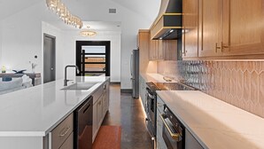 Una cocina moderna con una isla central, electrodomésticos de acero inoxidable y armarios de madera.