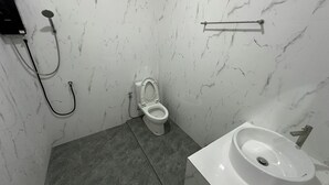 A bathroom with a toilet, bidet, and sink.