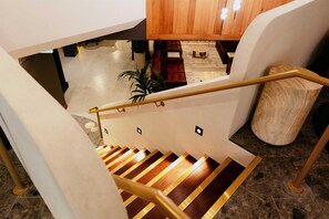 A staircase with a wooden handrail and a white wall.
